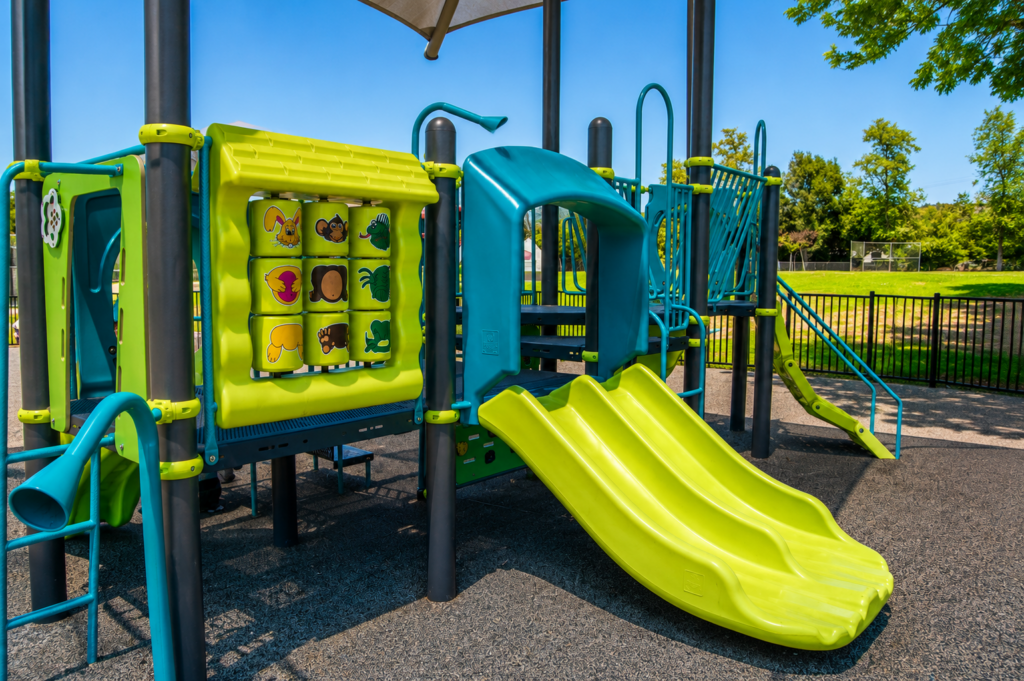 Commercial playground with triple slide and interactive activity panel at Mountain View Park in Escondido, California, installed by Western States Builders.